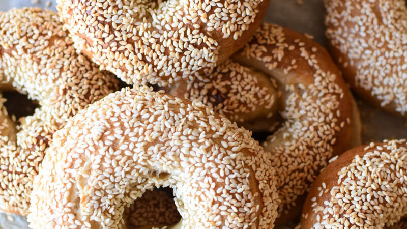 a pile of sesame sourdough bagels